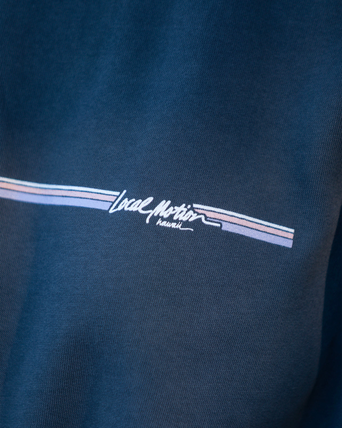 Close-up of a dark navy blue fabric garment featuring a graphic of local motion