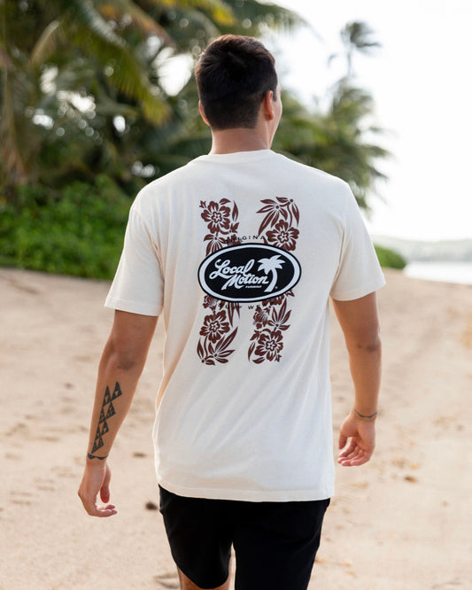 A man walking on a sandy beach seen from behind, wearing a cream-colored t-shirt [parchment]