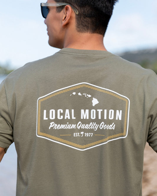 A man wearing an olive green t-shirt, viewed from behind, showing a large graphic on the back  [military]