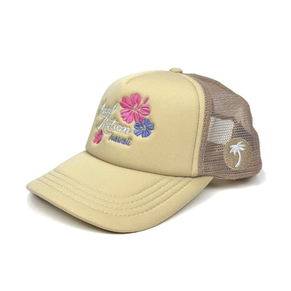 Beige trucker hat with floral designs and 'Local Motion Hawaii' text in white and palm tree patch in white on beige background