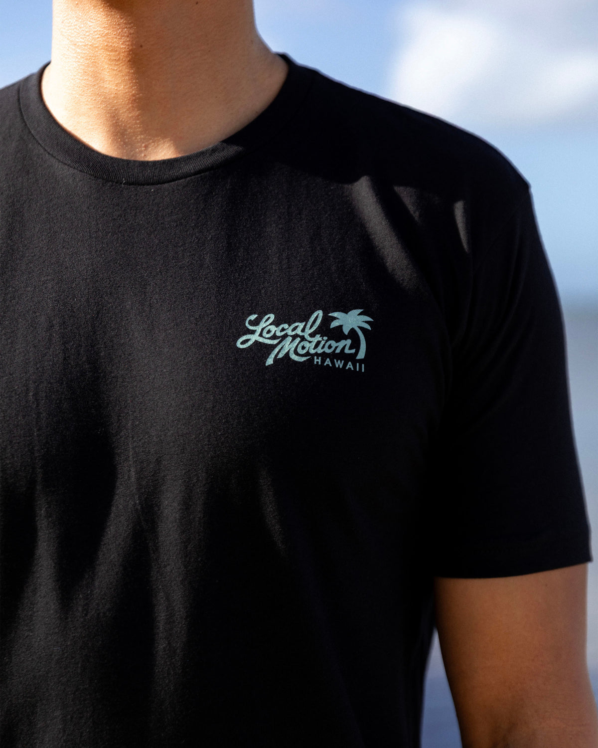 A close-up of a person wearing a black short-sleeve t-shirt [black]